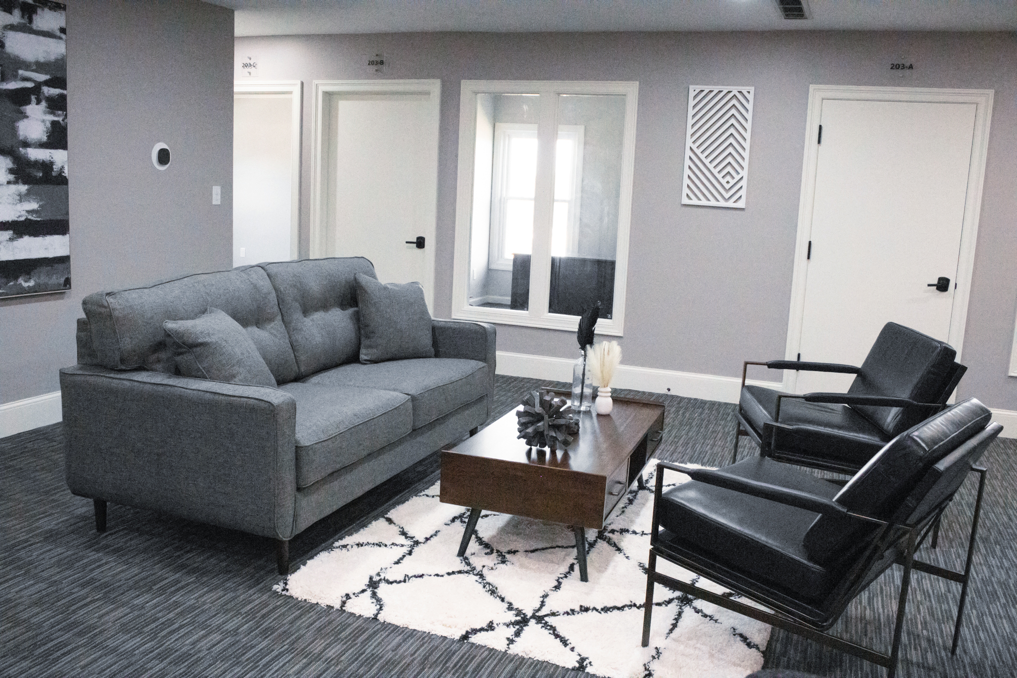 Loveseat and two leather chairs in the comfortable seating area of Suite 203 at Akron Spaces