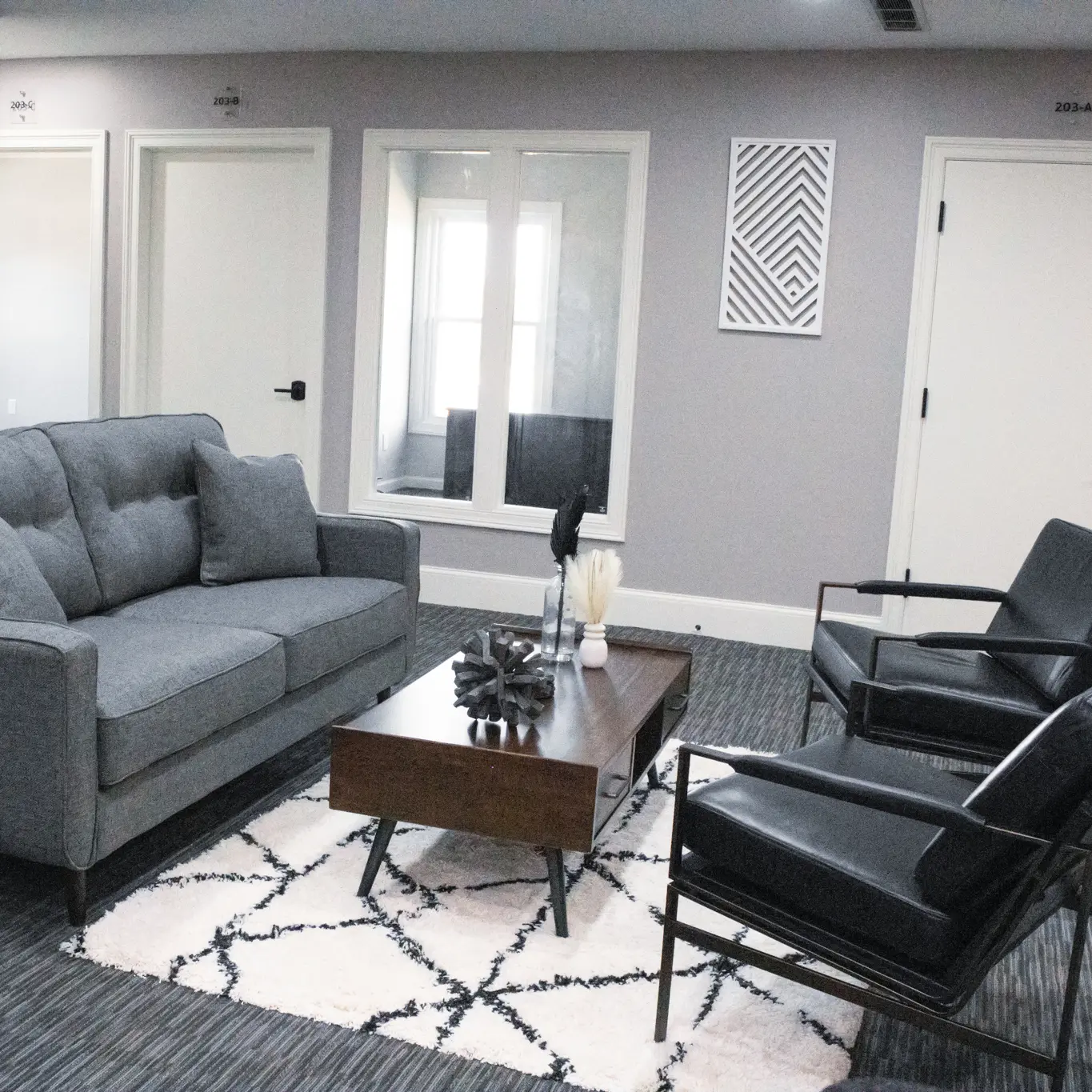Loveseat and two leather chairs in the comfortable seating area of Suite 203 at Akron Spaces