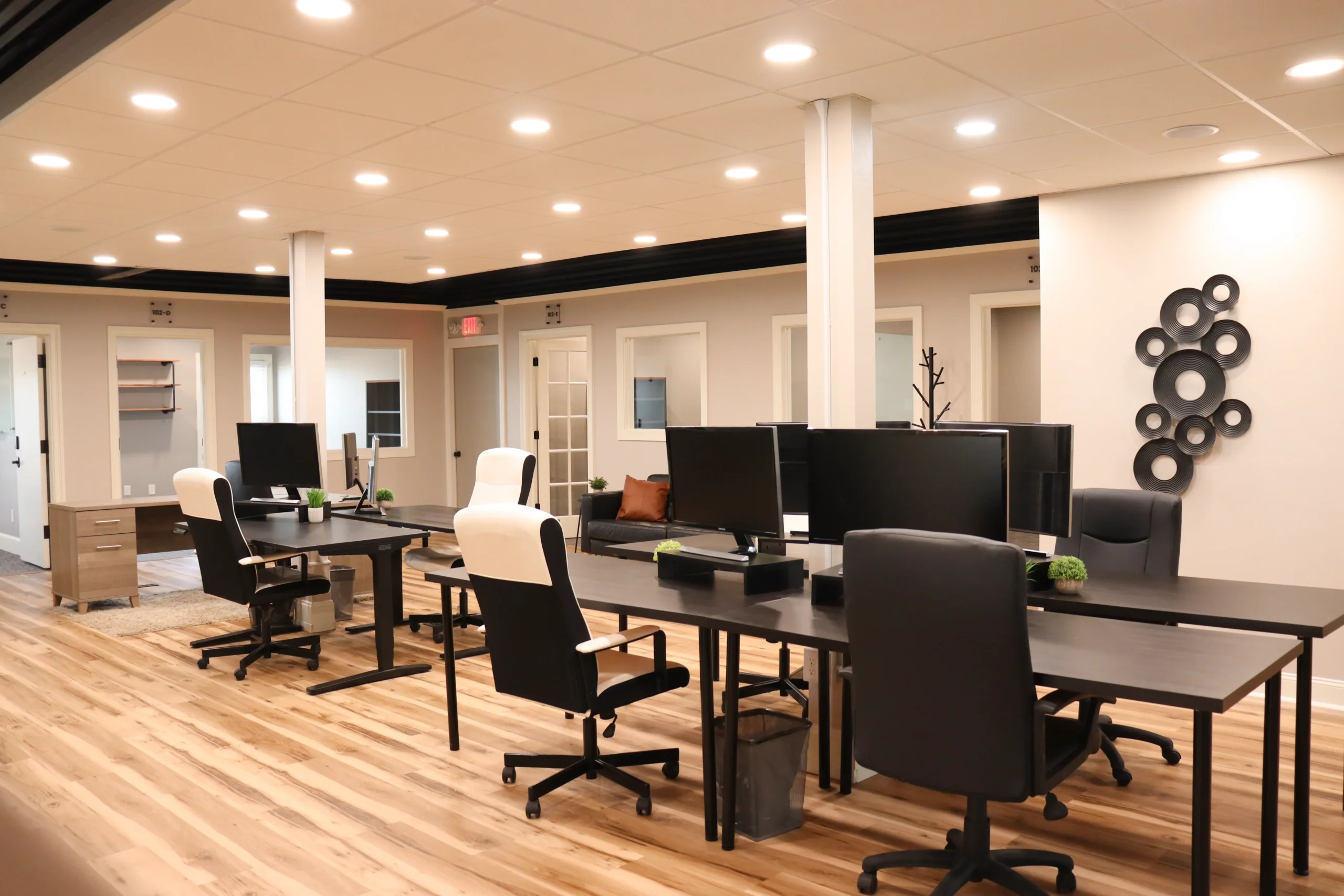 A spacious, open coworking area featuring seven desks available for rent on a daily basis