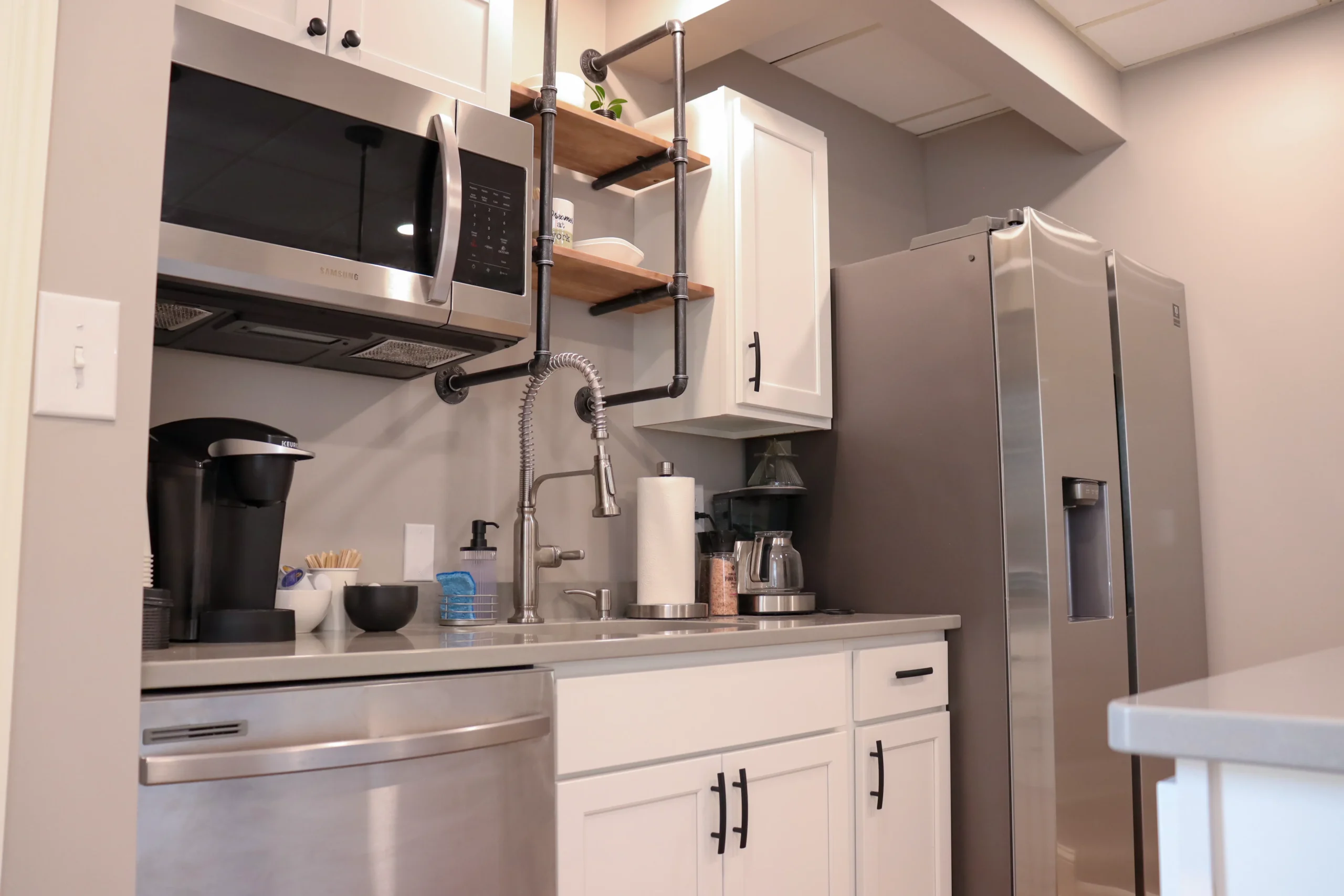 Kitchen amenities in Suite 102, including microwave, dishwasher, and coffee setup at Akron Spaces